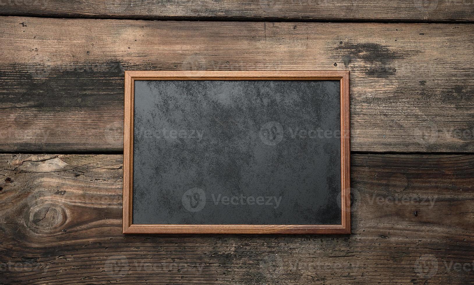 wooden empty chalk board on a brown wooden background photo
