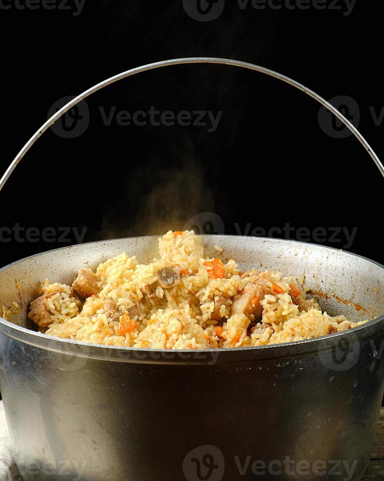 Pilaf is an oriental dish of boiled rice with fat and slices of meat and spices photo