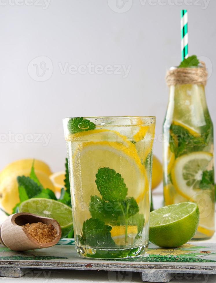 summer refreshing drink lemonade with lemons, mint leaves, lime in a glass photo