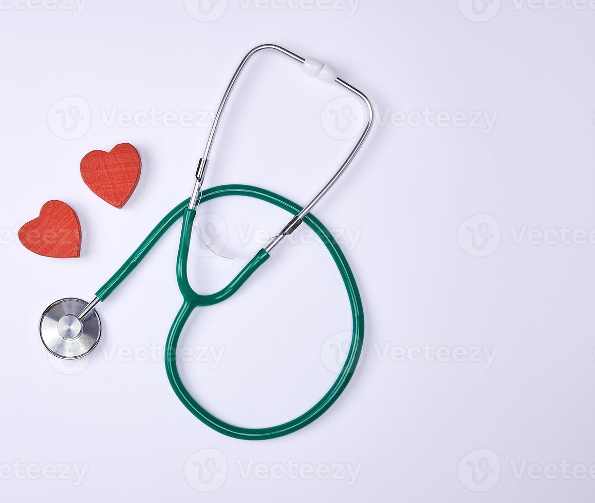 green medical stethoscope and two red decorative hearts photo