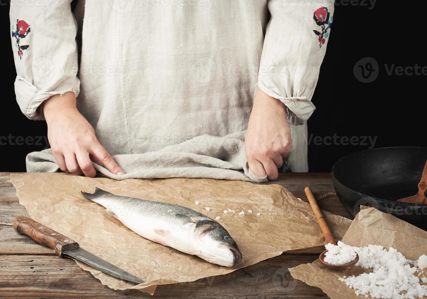 fresh whole sea bass fish lies on the table, cooking process photo