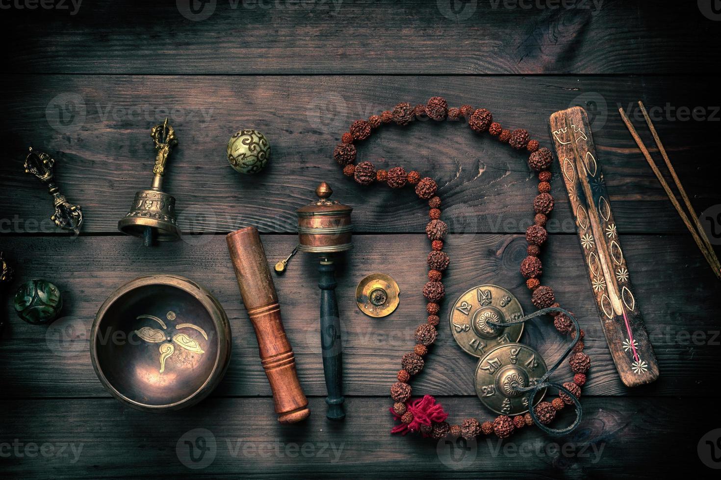 Copper singing bowl, prayer beads, prayer drum and other Tibetan religious objects for meditation photo