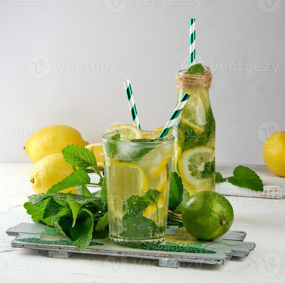 summer refreshing drink lemonade with lemons, mint leaves, lime in a glass photo
