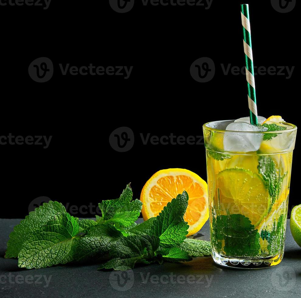 refreshing drink lemonade with lemons, mint leaves, ice cubes and lime in a glass photo