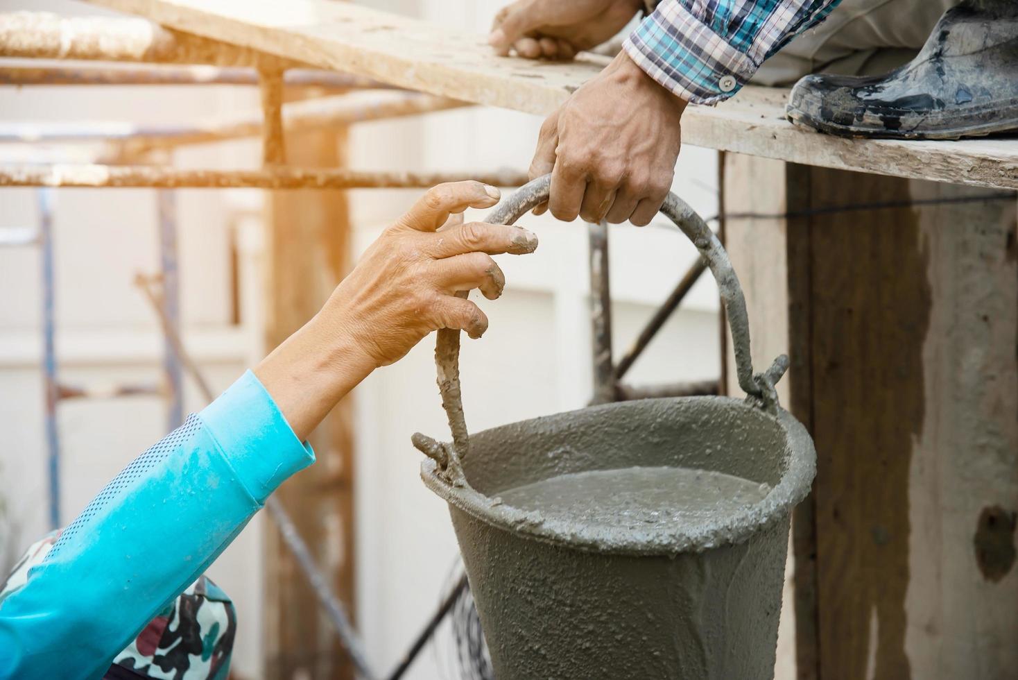 builder contractor man transfers mix fresh concrete in industry work project, prepare to pour wet liquid material into the form in construction site as professional employment photo