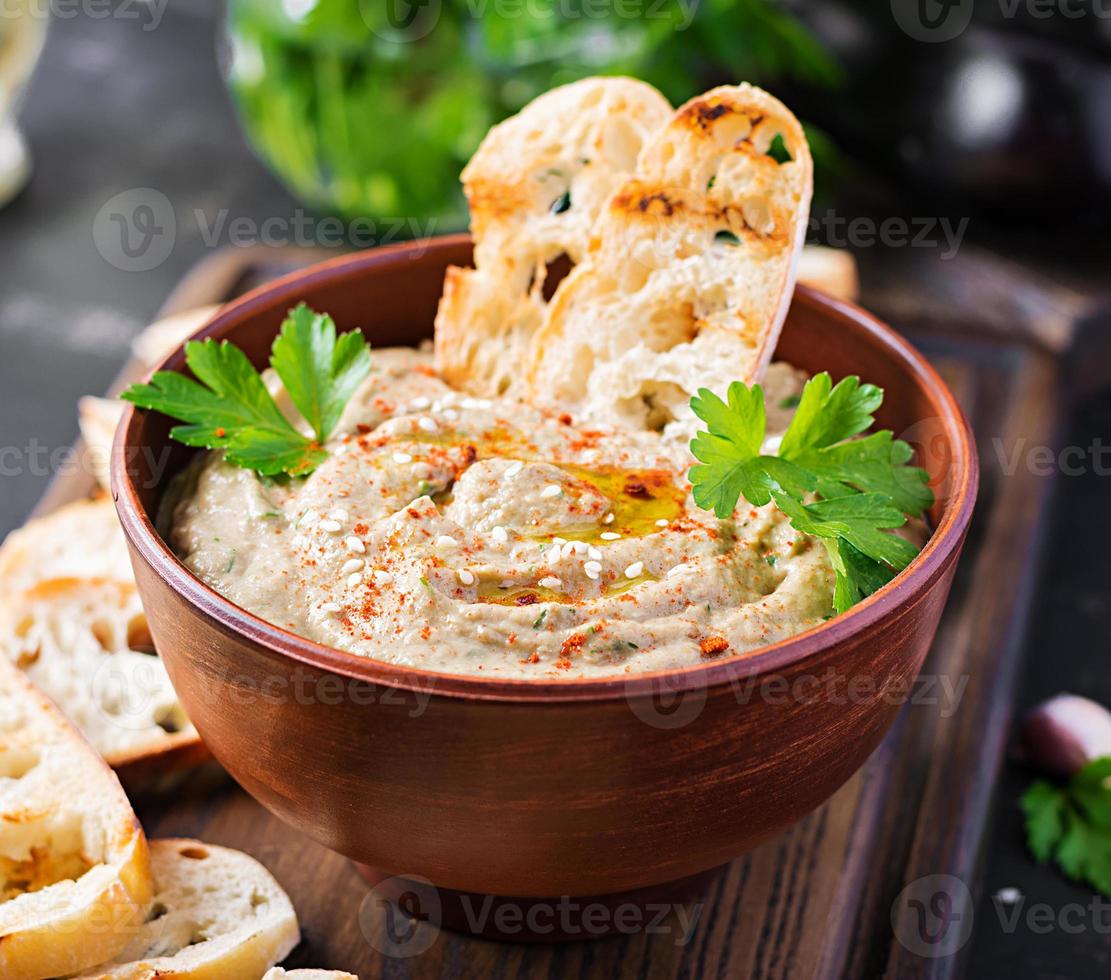 Baba ghanoush vegan hummus from eggplant with seasoning, parsley and toasts. Baba ganoush. Middle Eastern cuisine. photo