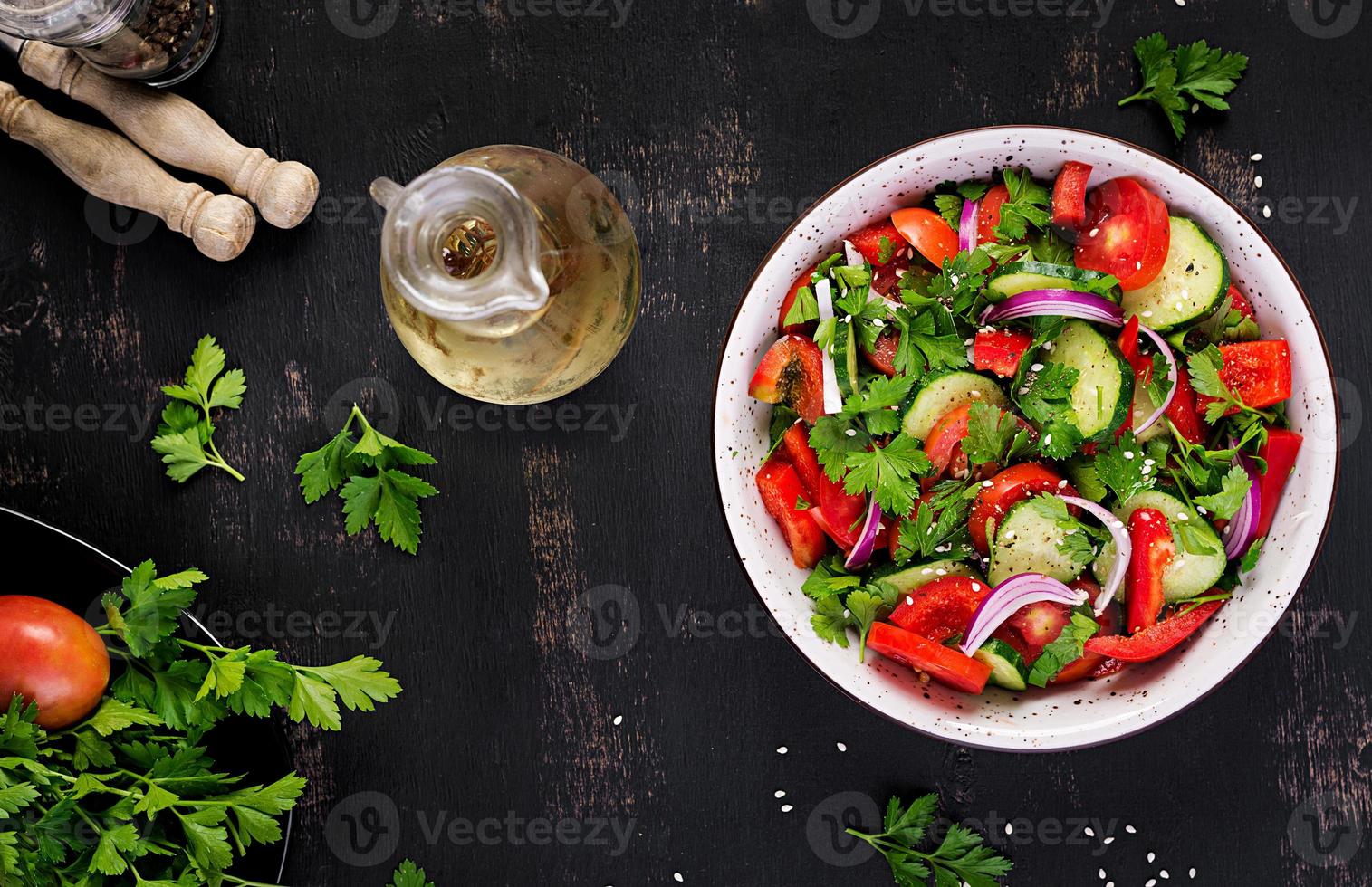 tomate y Pepino ensalada con rojo cebolla, pimenton, negro pimienta y perejil. vegano alimento. dieta menú. parte superior vista. plano laico foto