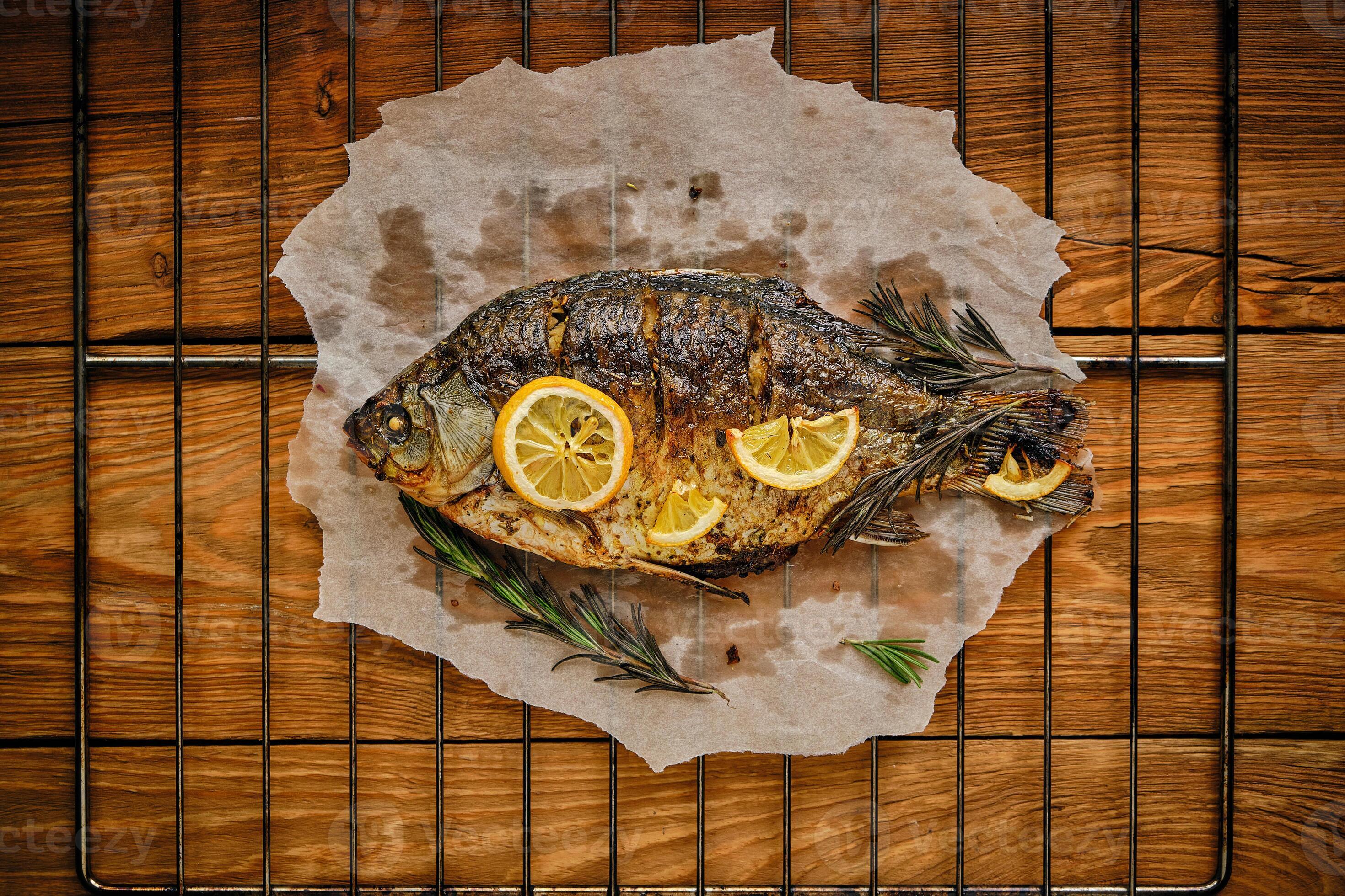 Baked fish cooked on parchment paper with spices, lemon and rosemary