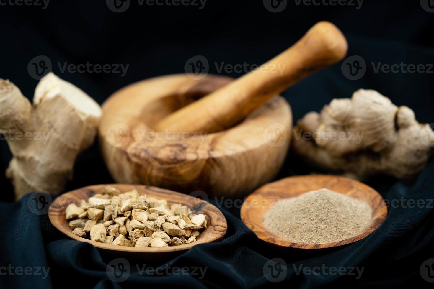 fresh ginger and dried ginger powder on olive wood photo
