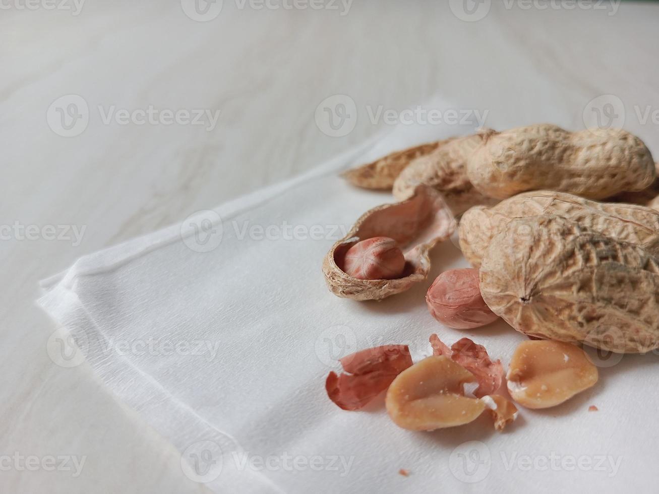 Side view of peanuts on a textured table, peanut shells photo