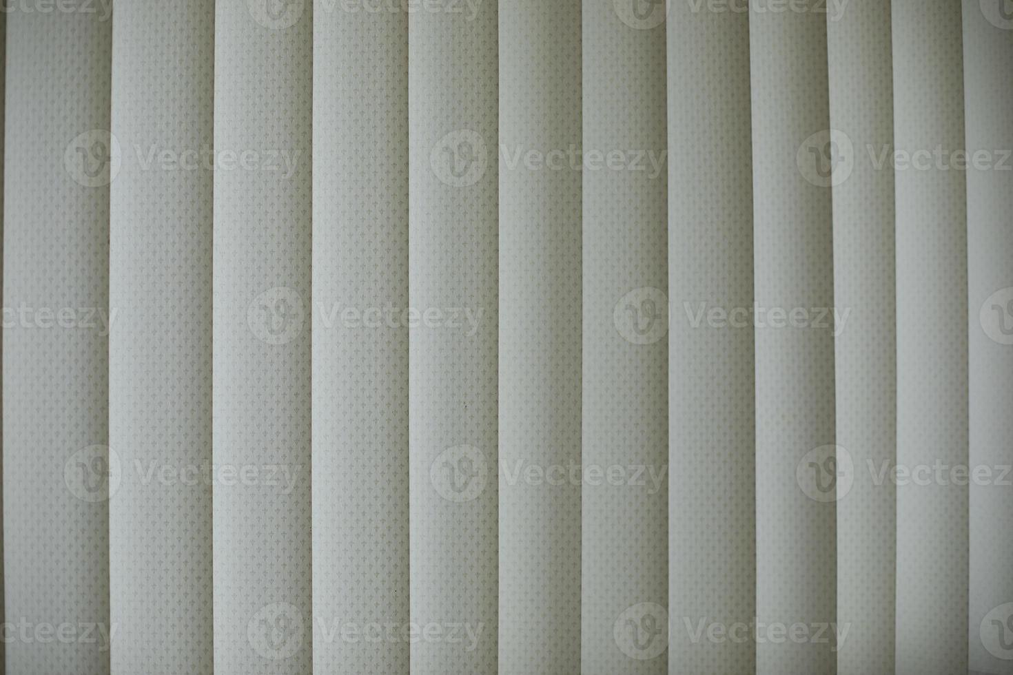 Blinds are white. Vertical blinds on window. Light from window. photo