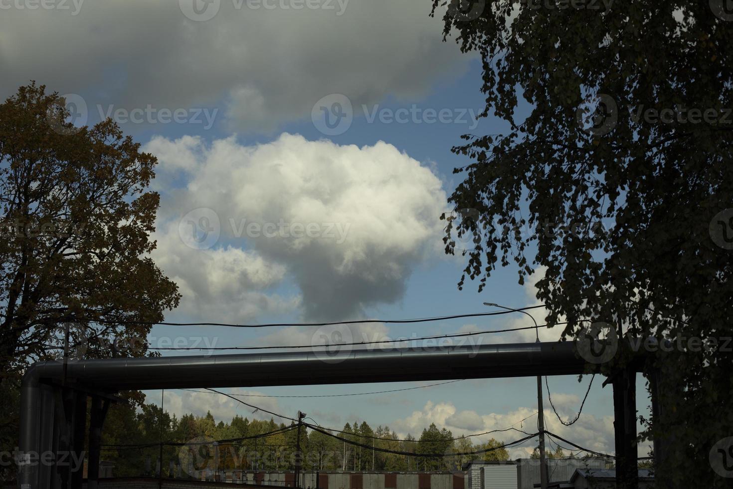 Cloud over garages. White cloud in sky. Weather in summer. photo