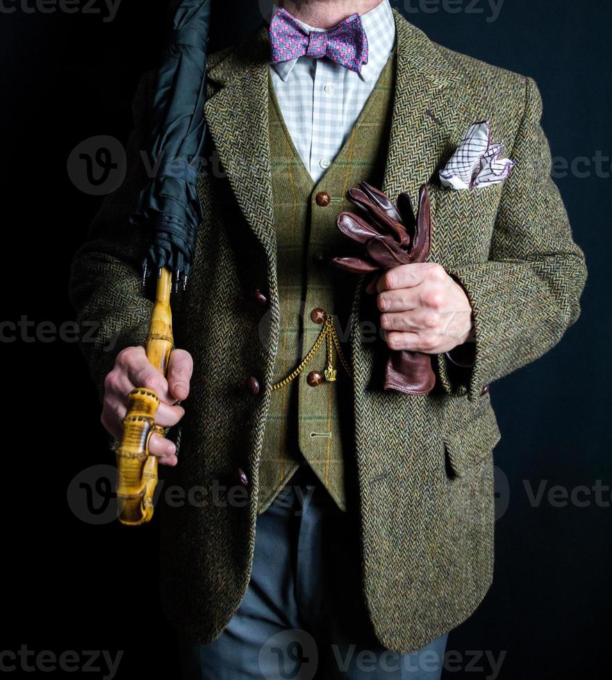 Portrait of Businessman in Tweed Suit Holding Umbrella and Leather Gloves. Vintage Style and Retro Fashion of Elegant English Gentleman. photo