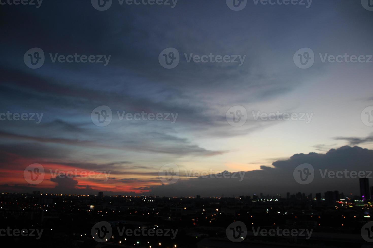 sunset dark blue cloud with white golden light sky background and city light midnight evening time photo