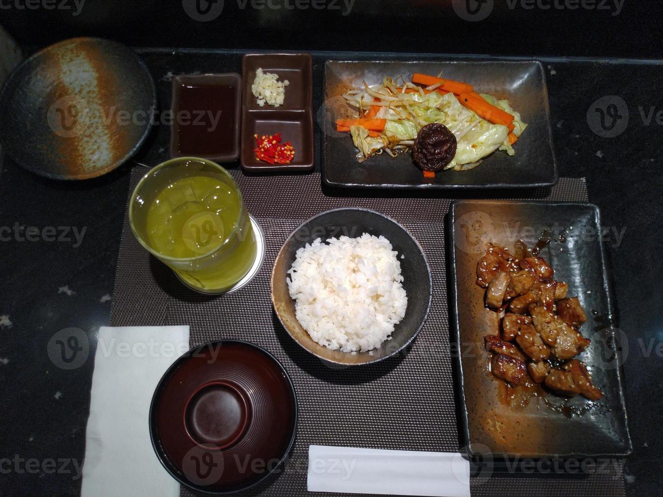 miso soup , green tea , rice , stir fry chicken and vegetable , Japanese food set in the restaurant table photo