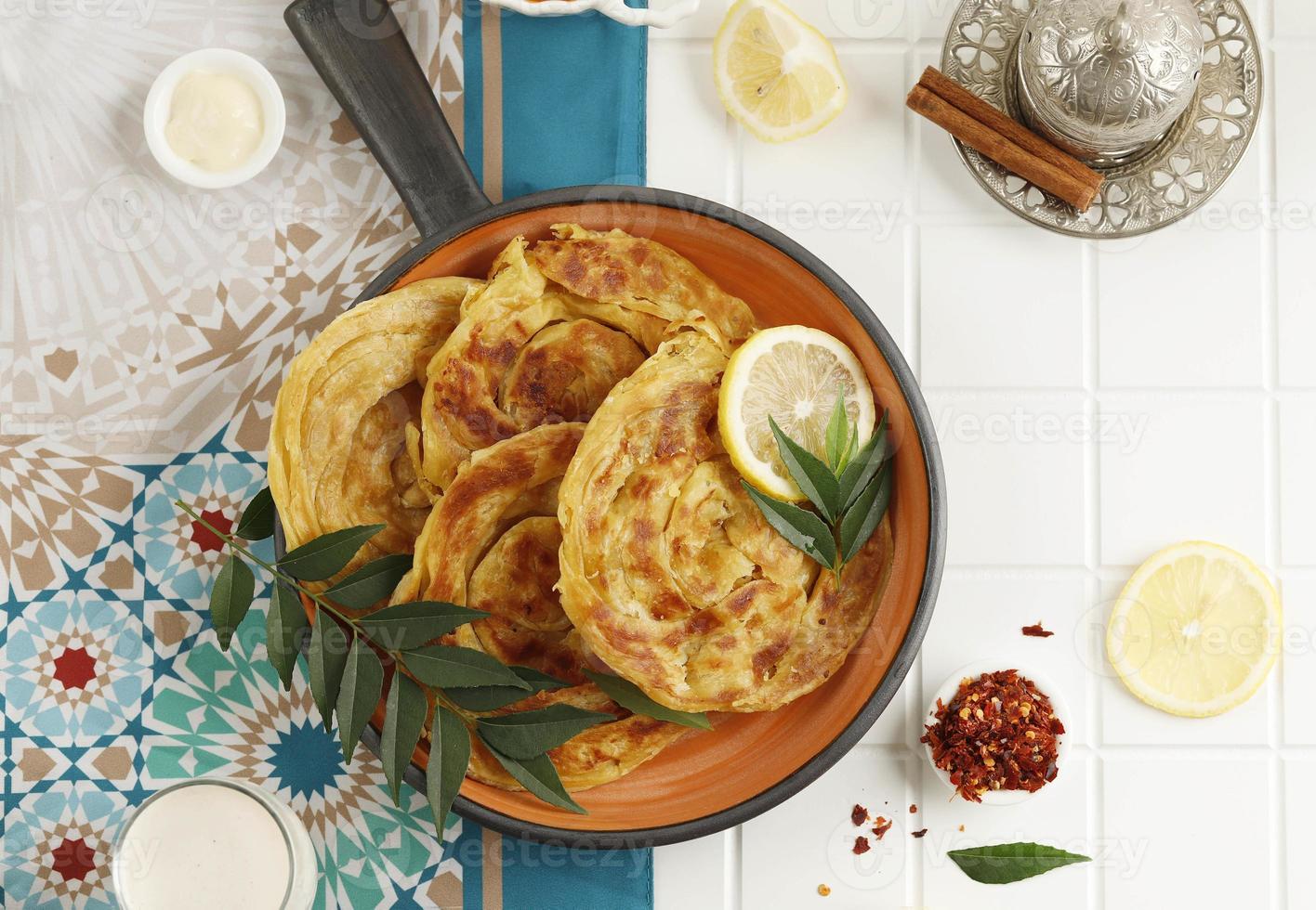 Roti Parata or Roti Canai with Lamb Curry Sauce and Lemon photo