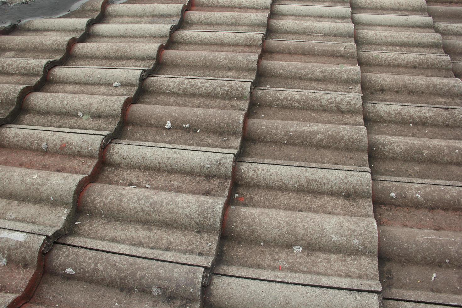 Old, dirty, and covered in dusty housing roof tile from clay. Outdoor house architecture photo. photo