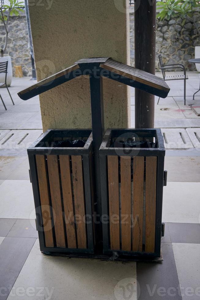 Single rubbish bin, garbage and waste bin made of wooden material. A garbage collection tank in the corner of building. A clean container for household waste.  Wooden waste boxes or trash bin. photo