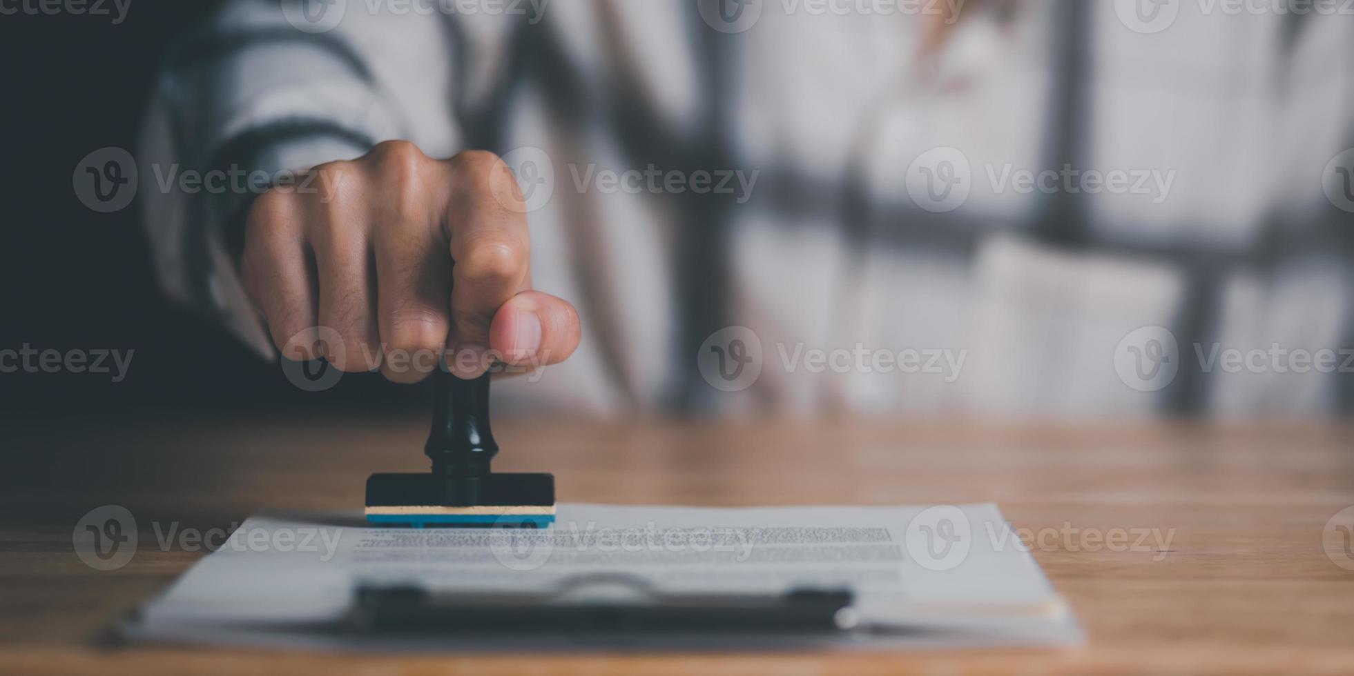 Businessman validates and manages business documents and agreements, signing a business contract approval, joint venture agreement, financial certificate, approval stamp ,stamping in the contract photo