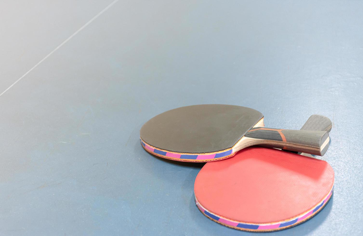 raquetas de ping pong y pelotas en la mesa foto