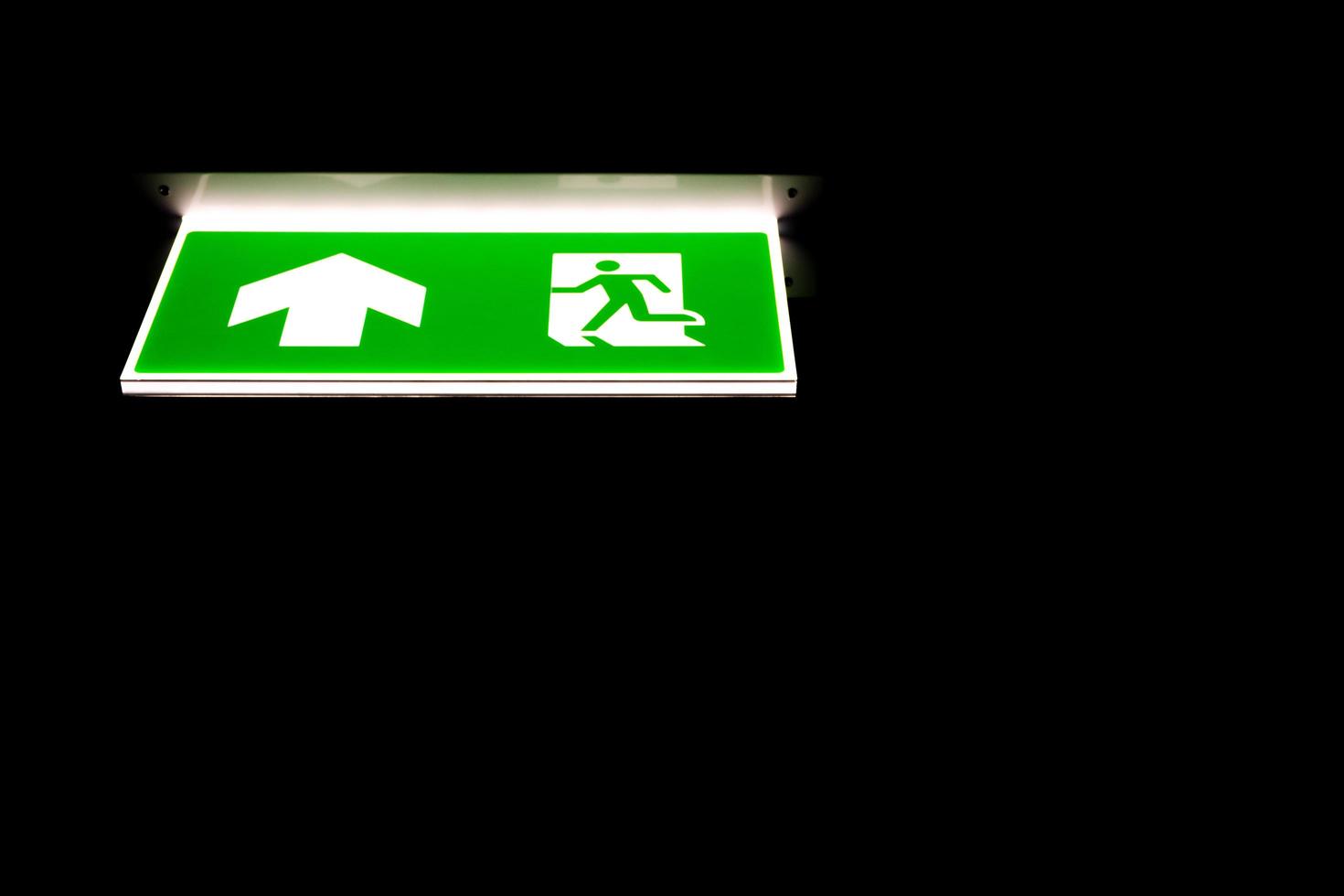 Green emergency exit sing in darkness photo