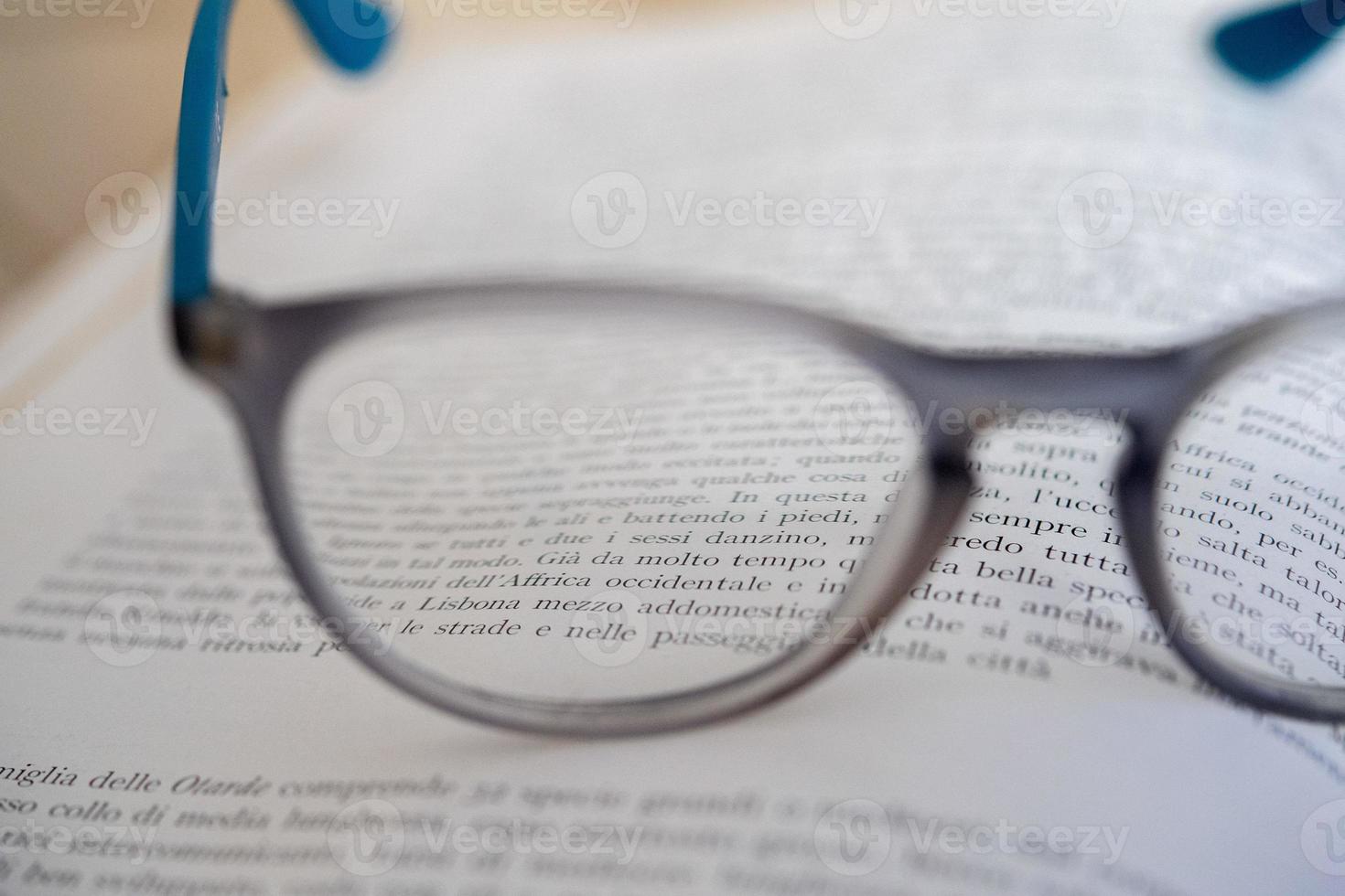 light blue reading glasses isolated on a book photo