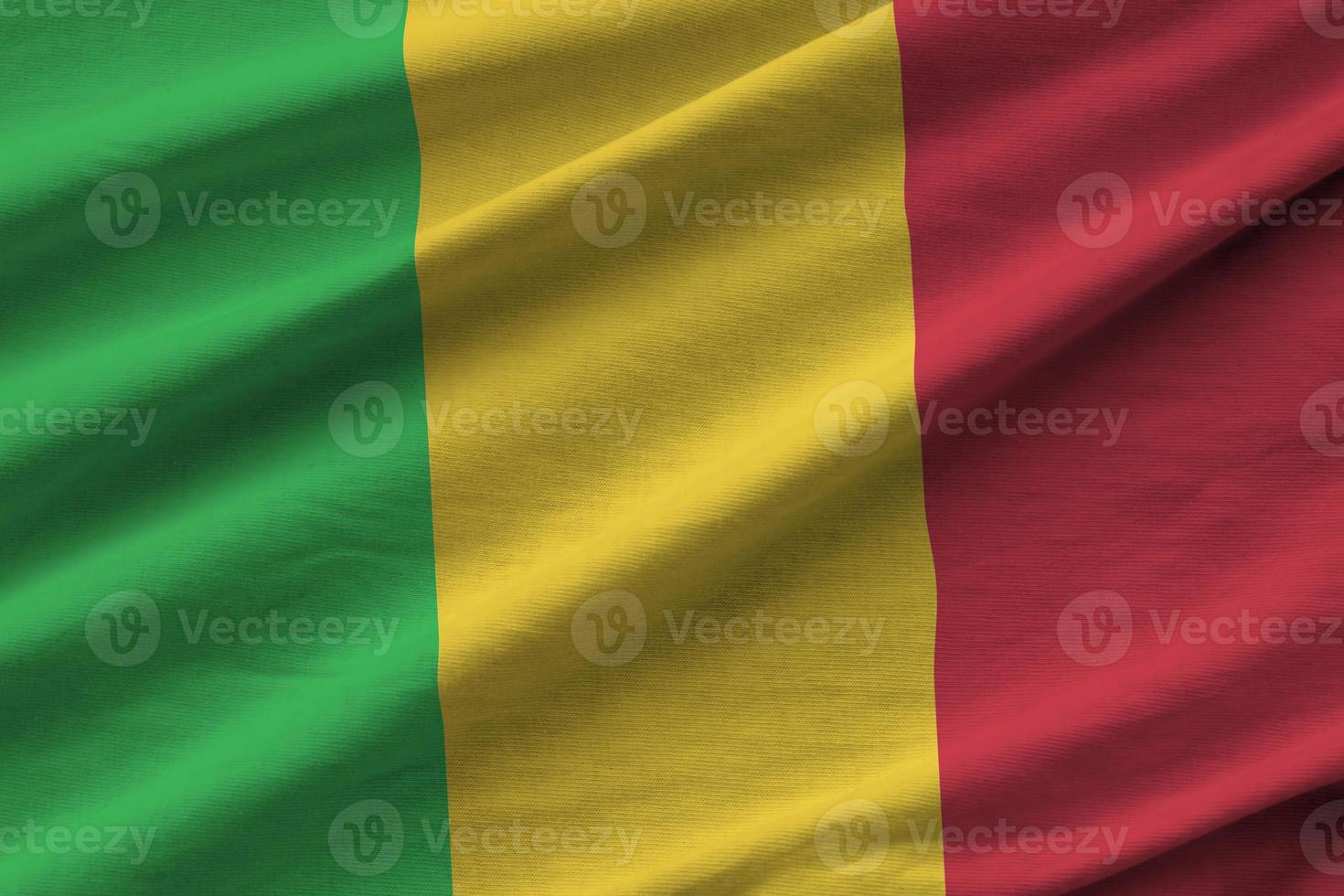 Mali flag with big folds waving close up under the studio light indoors. The official symbols and colors in banner photo