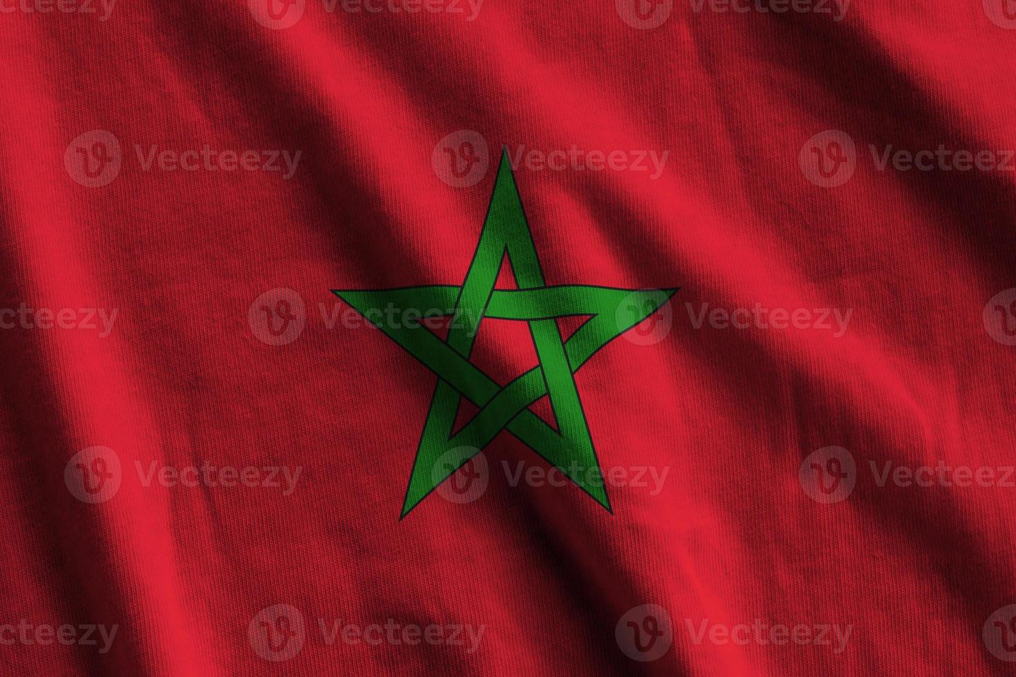 Morocco flag with big folds waving close up under the studio light indoors. The official symbols and colors in banner photo