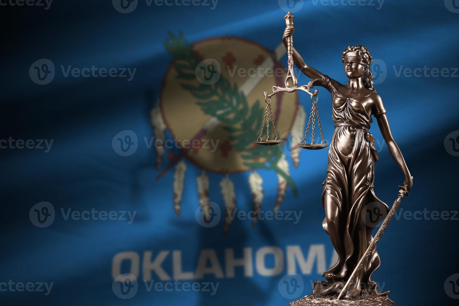 Oklahoma US state flag with statue of lady justice and judicial scales in dark room. Concept of judgement and punishment photo