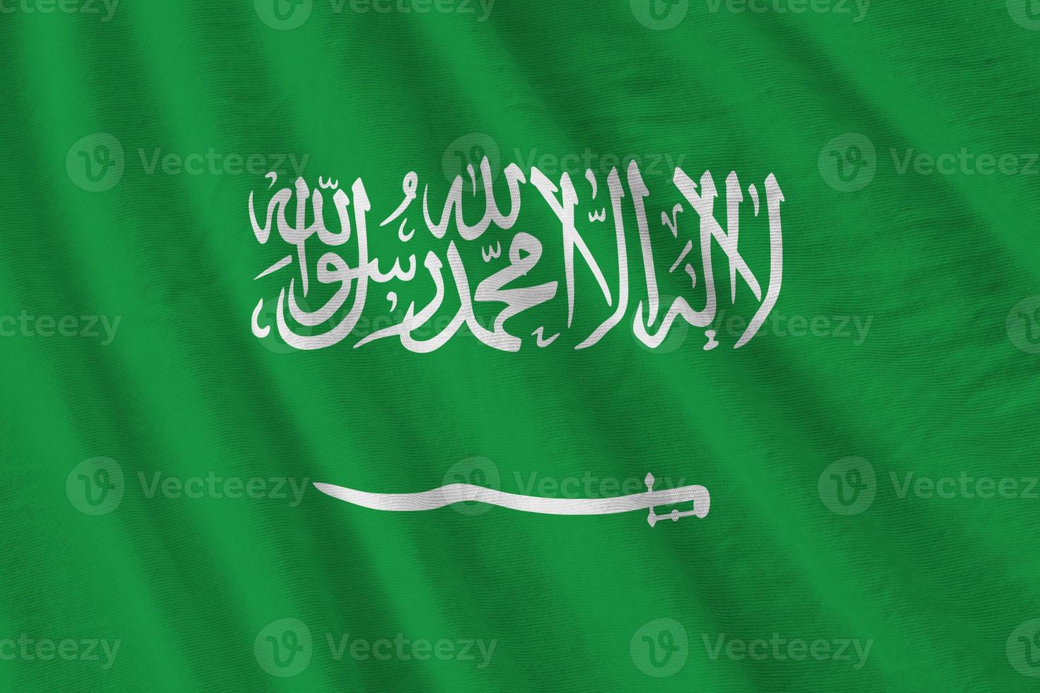 Saudi Arabia flag with big folds waving close up under the studio light indoors. The official symbols and colors in banner photo