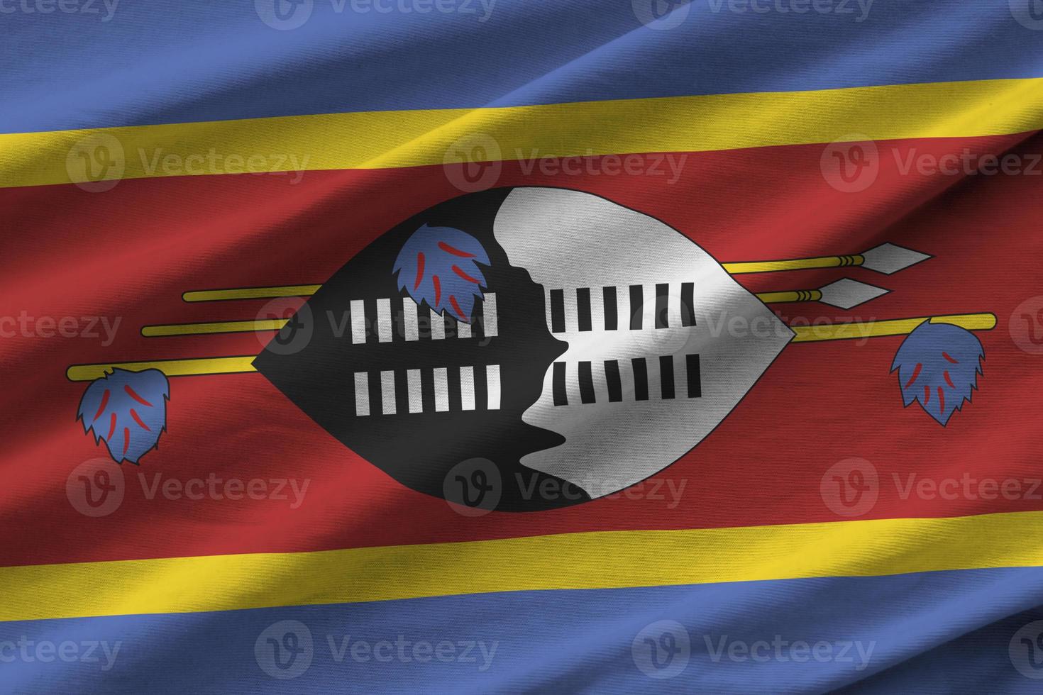 Swaziland flag with big folds waving close up under the studio light indoors. The official symbols and colors in banner photo