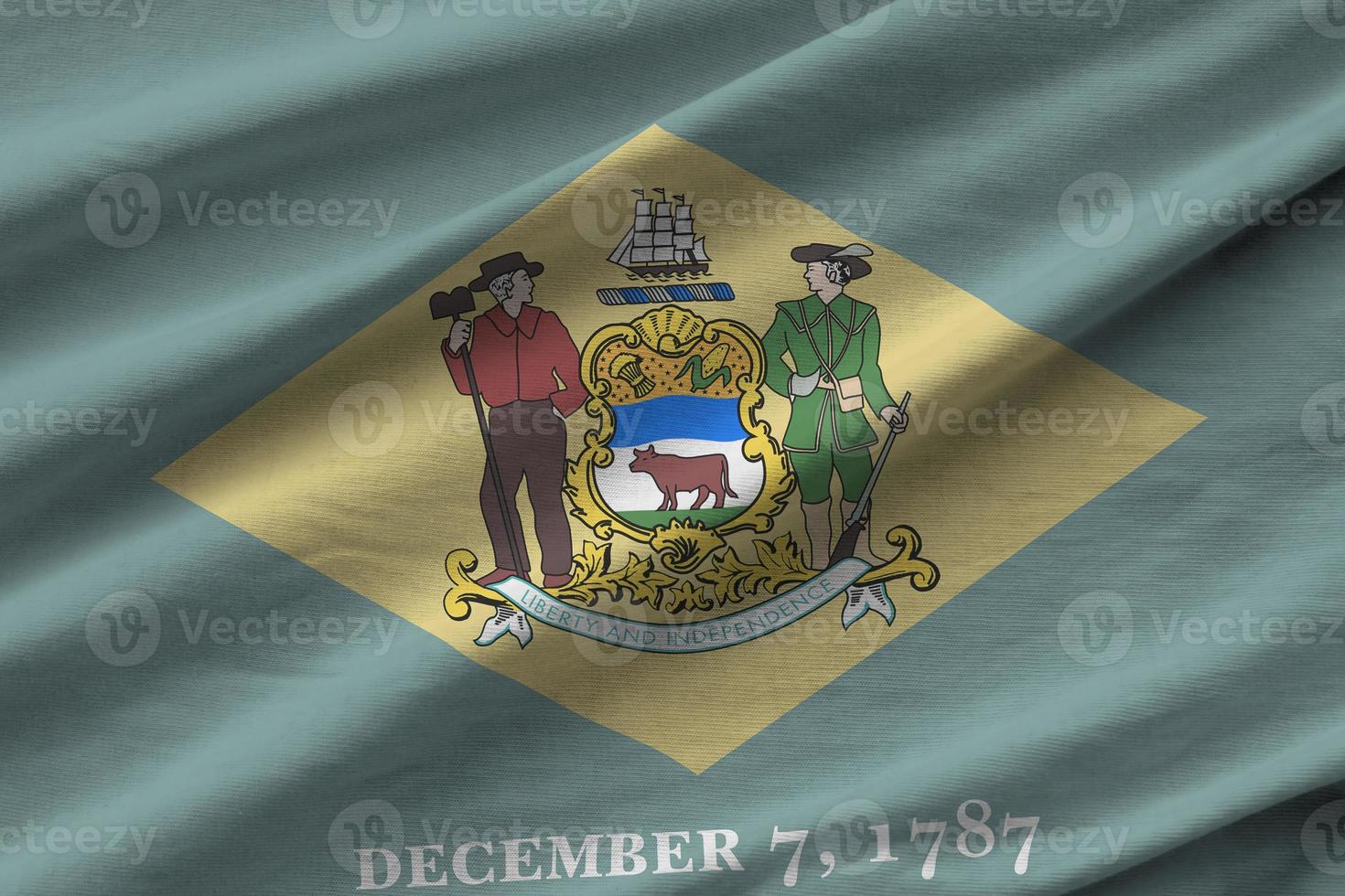 Delaware US state flag with big folds waving close up under the studio light indoors. The official symbols and colors in banner photo