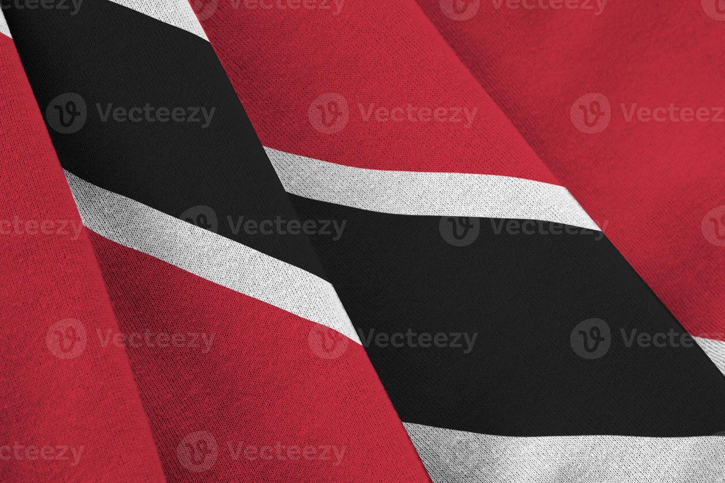 Trinidad and Tobago flag with big folds waving close up under the studio light indoors. The official symbols and colors in banner photo