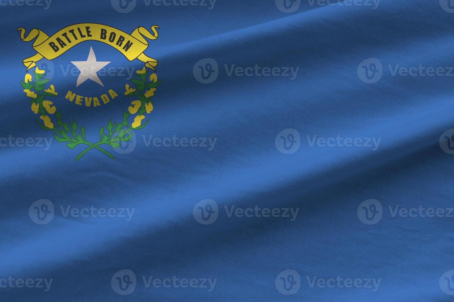 Nevada US state flag with big folds waving close up under the studio light indoors. The official symbols and colors in banner photo