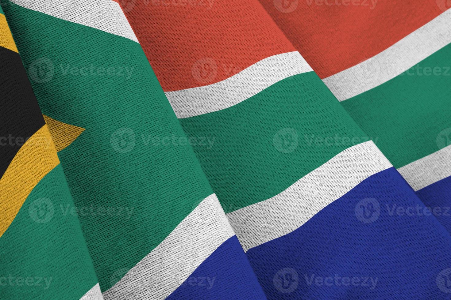 bandera de sudáfrica con grandes pliegues ondeando de cerca bajo la luz del estudio en el interior. los símbolos y colores oficiales en banner foto