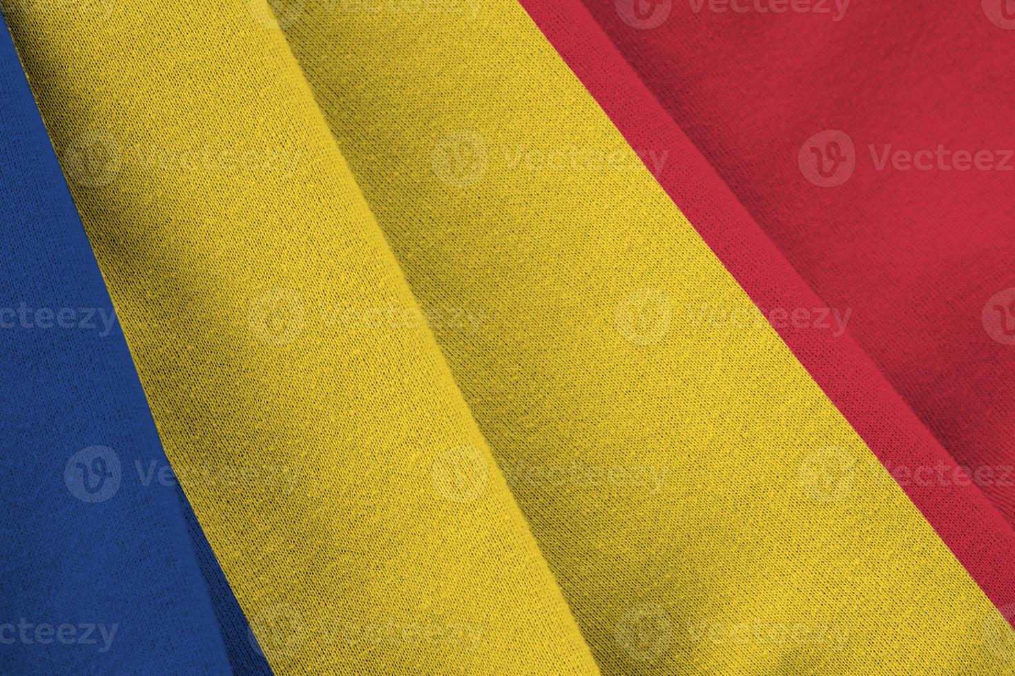 bandera de rumania con grandes pliegues ondeando de cerca bajo la luz del estudio en el interior. los símbolos y colores oficiales en banner foto