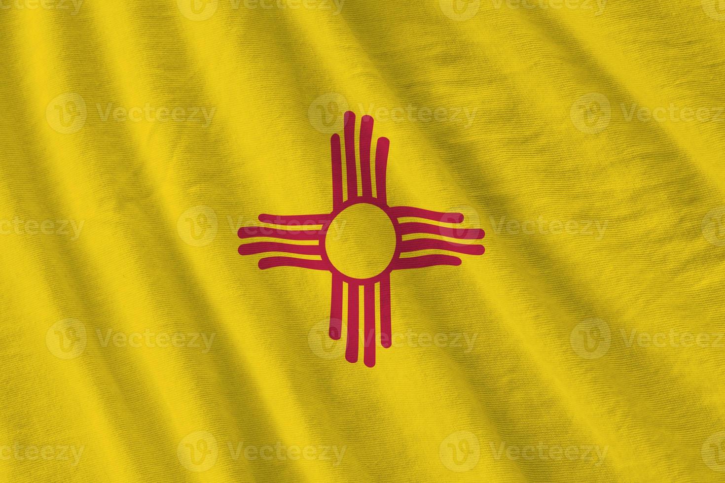 New Mexico US state flag with big folds waving close up under the studio light indoors. The official symbols and colors in banner photo