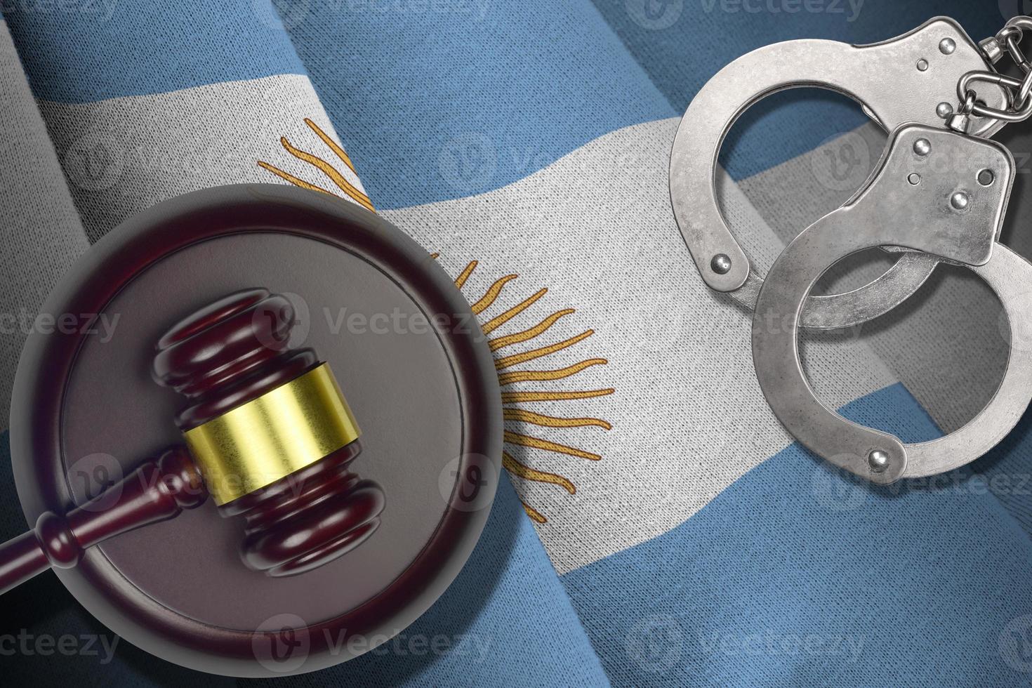 Argentina flag with judge mallet and handcuffs in dark room. Concept of criminal and punishment, background for judgement topics photo