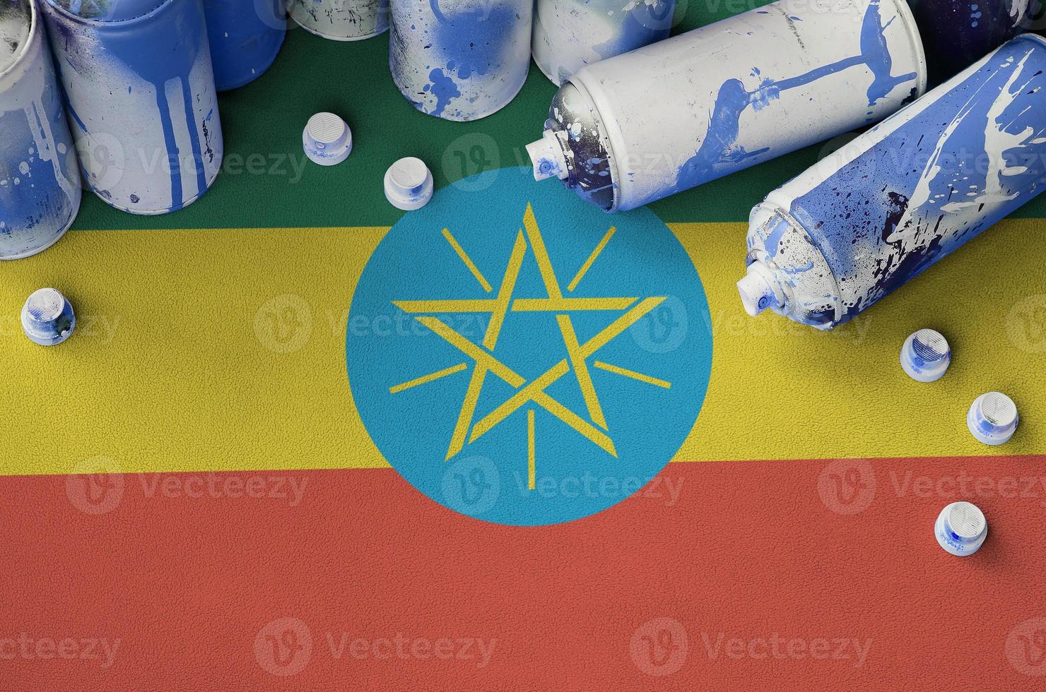 Ethiopia flag and few used aerosol spray cans for graffiti painting. Street art culture concept photo