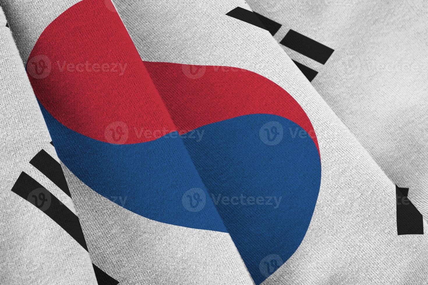 South Korea flag with big folds waving close up under the studio light indoors. The official symbols and colors in banner photo