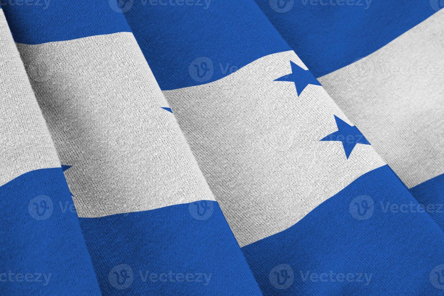 Honduras flag with big folds waving close up under the studio light indoors. The official symbols and colors in banner photo