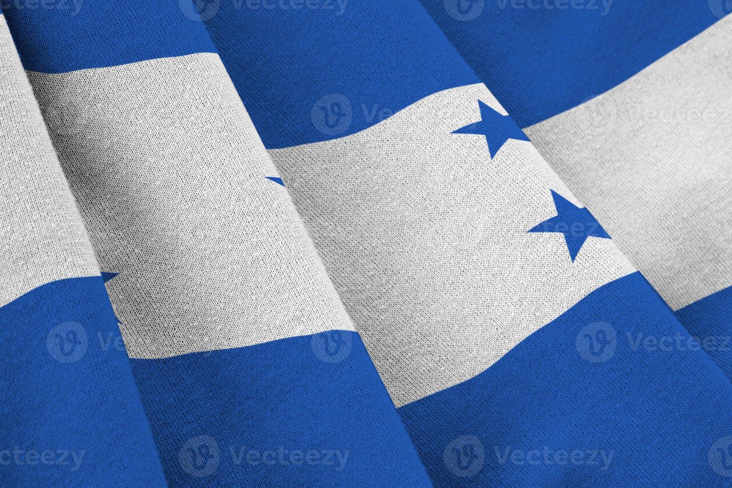 bandera de honduras con grandes pliegues ondeando de cerca bajo la luz del estudio en el interior. los símbolos y colores oficiales en banner foto