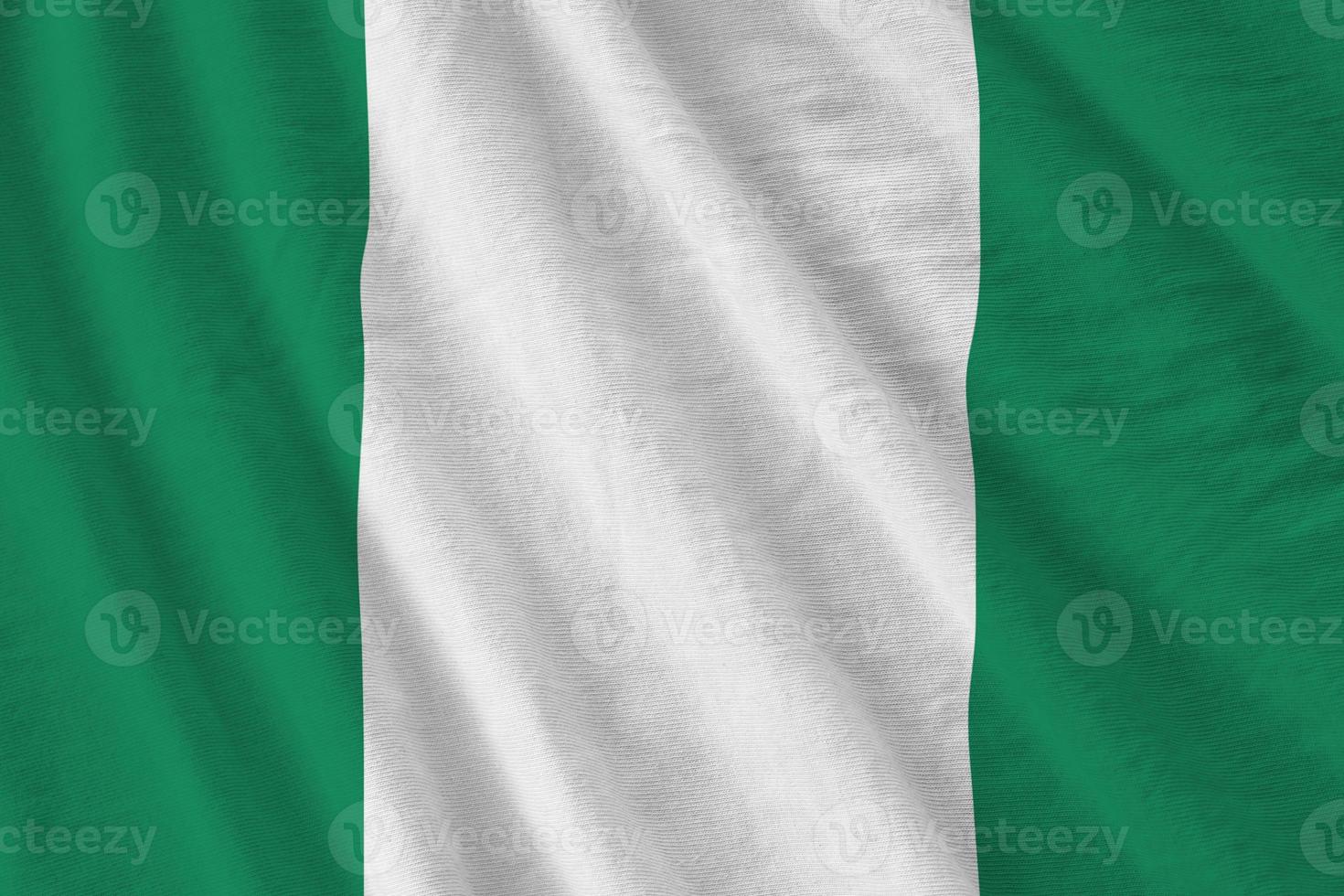 Nigeria flag with big folds waving close up under the studio light indoors. The official symbols and colors in banner photo