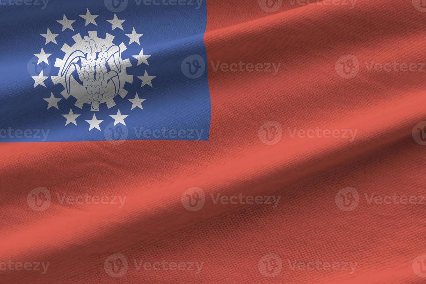 Myanmar flag with big folds waving close up under the studio light indoors. The official symbols and colors in banner photo