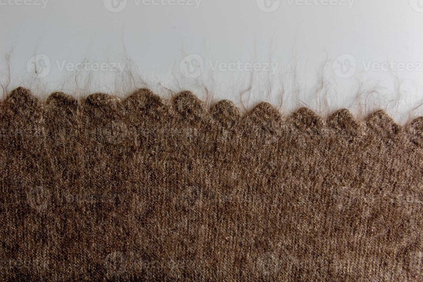 Close up on knit woolen fur texture. Melange fluffy woven thread sweater or scarf as a background. photo