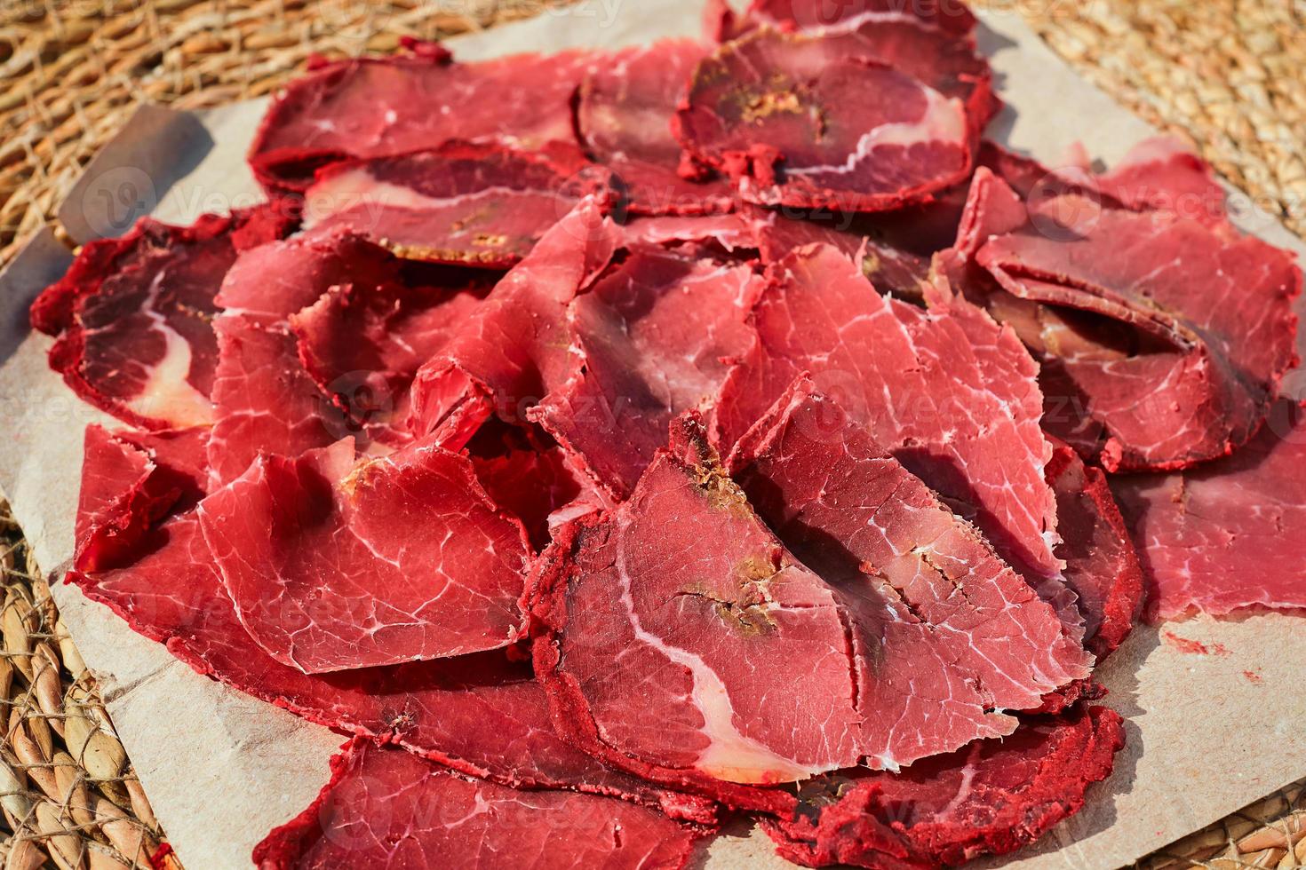 Dried meat, bacon, or Turkish pastirma close-up, selective focus on meat traditional dish, traditional Turkish food photo