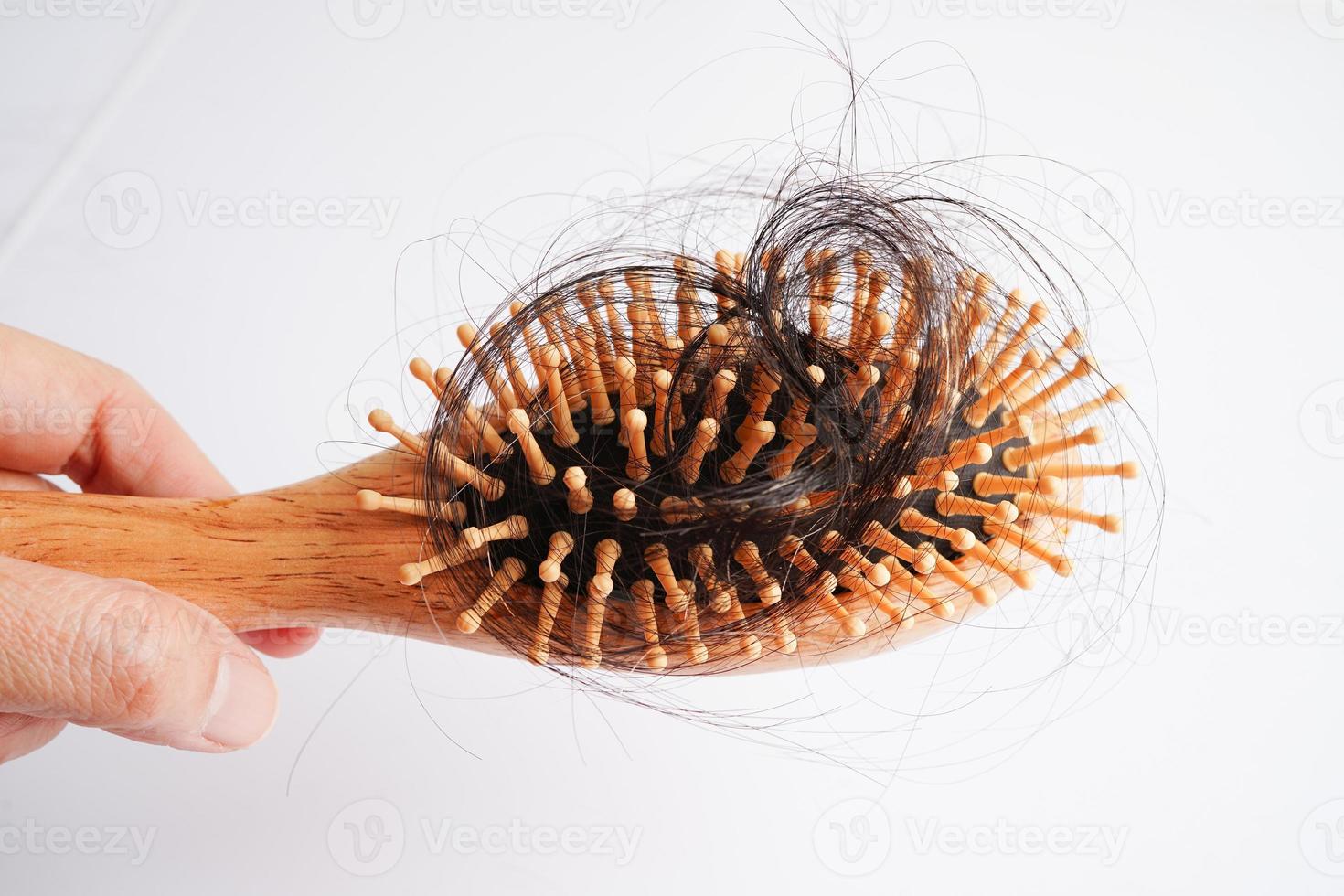 Asian woman have problem with long hair loss attach to comb brush. photo