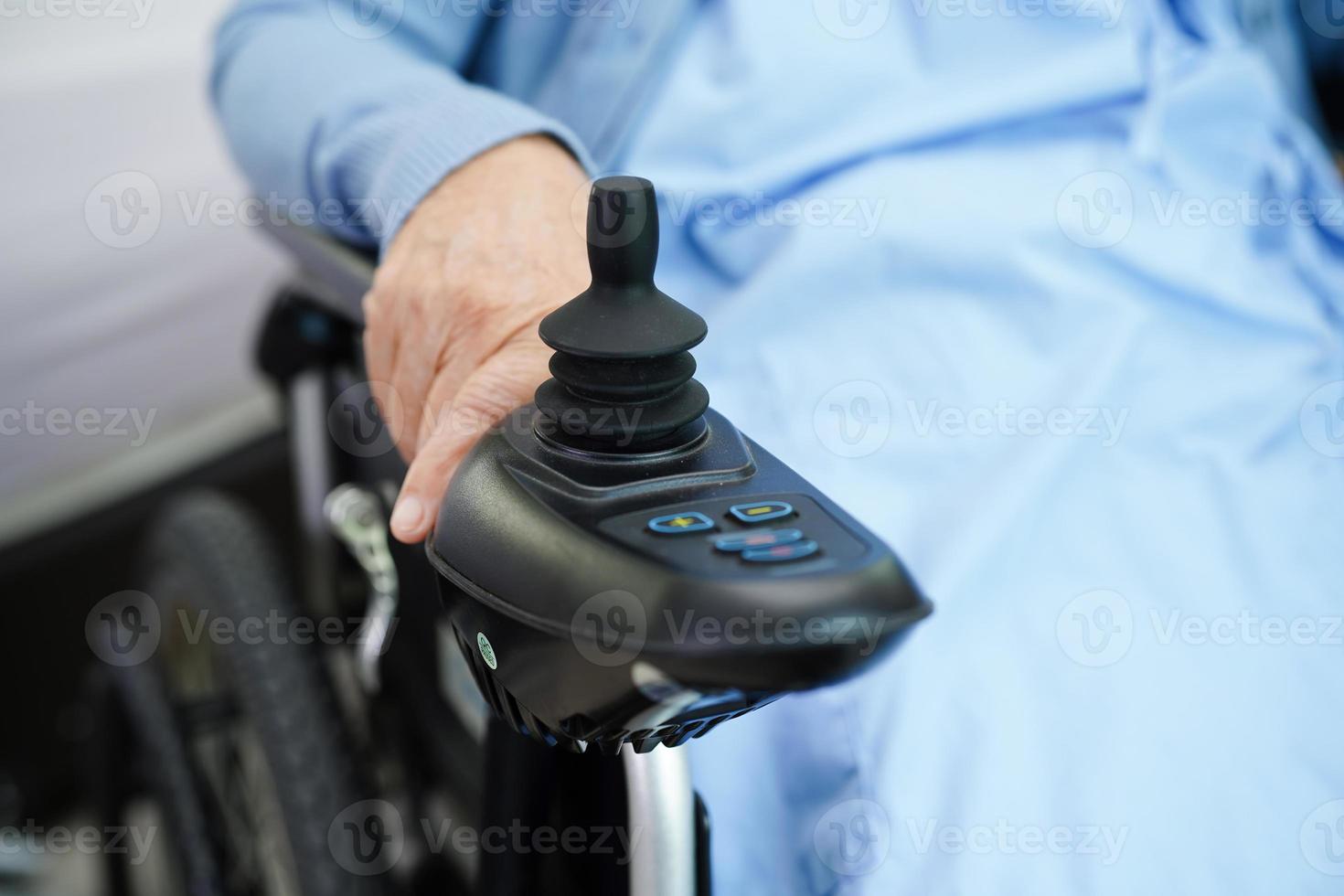 Asian elderly woman disability patient sitting on electric wheelchair in park, medical concept. photo