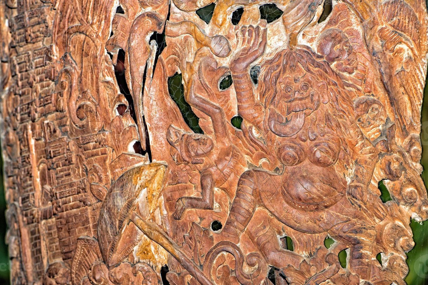 Buddha face carved wood spirit close up detail in indonesia photo