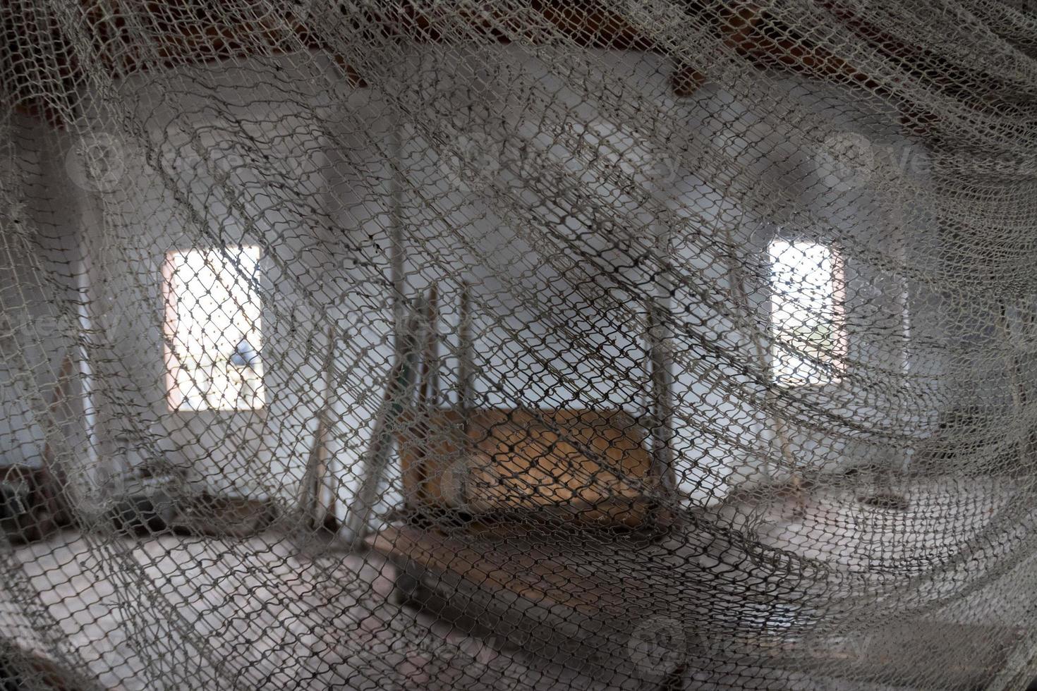 red de pesca antigua hecha a mano dentro de la casa del pescador foto